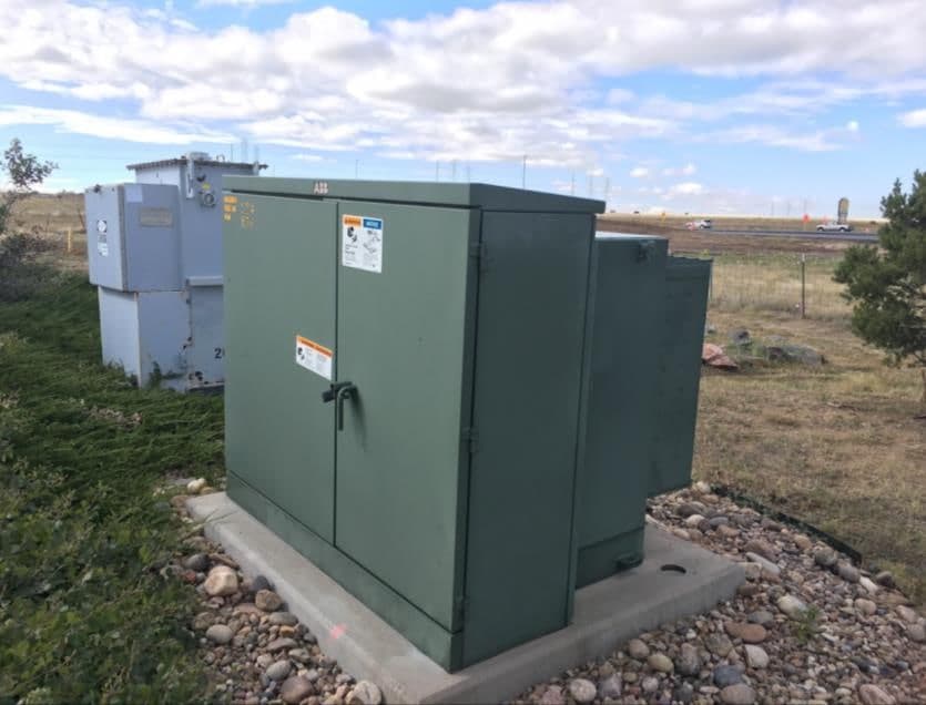 A pad-mounted distribution transformer on a concrete pad